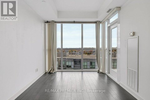 A spacious room with a view of the city through large windows.