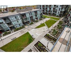 A view of a courtyard with a grassy area and a few trees.