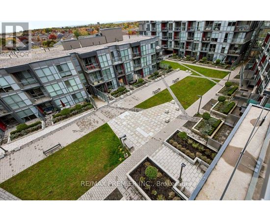 A view of a courtyard with a grassy area and a few trees.