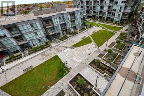 A view of a courtyard with a grassy area and a few trees.