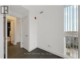 A white hallway with a door on the left and a balcony on the right.