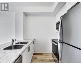 A kitchen with a refrigerator, sink, and countertop.