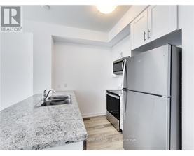 A kitchen with a granite countertop and a refrigerator.