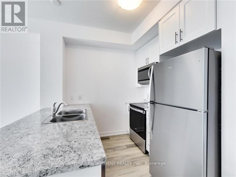 A kitchen with a granite countertop and a refrigerator.