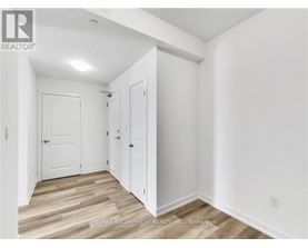A white room with a wooden floor and a door on the left.