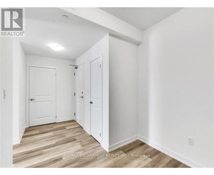 A white room with a wooden floor and a door on the left.