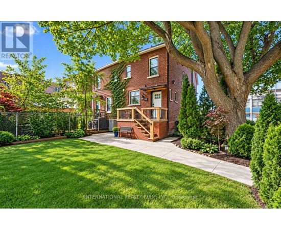 A tree in a yard in front of a house.
