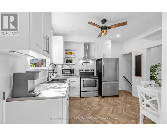 A modern kitchen with white cabinets and stainless steel appliances.
