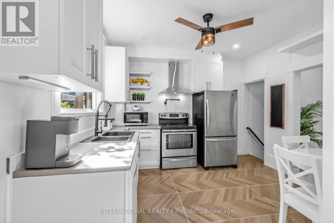 A modern kitchen with white cabinets and stainless steel appliances.
