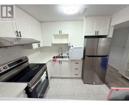 A kitchen with white cabinets and a stainless steel refrigerator.