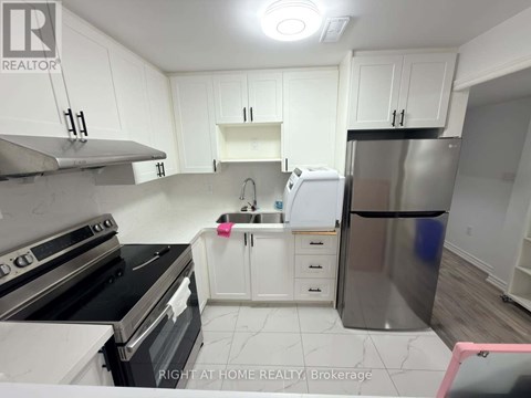 A kitchen with white cabinets and a stainless steel refrigerator.
