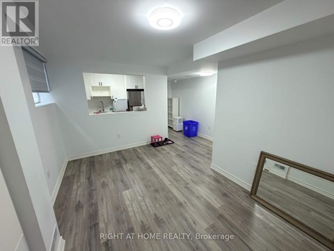 A room with a wooden floor and a mirror on the wall.