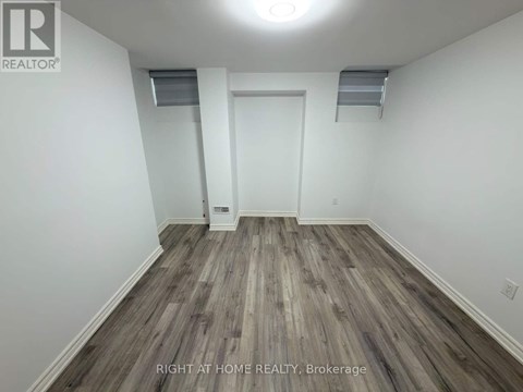A room with wood flooring and white walls.