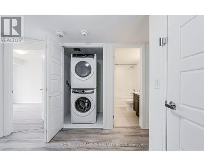 A white washing machine is in a small alcove in a home.