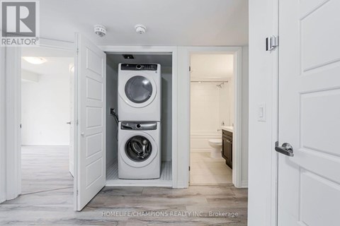 A white washing machine is in a small alcove in a home.