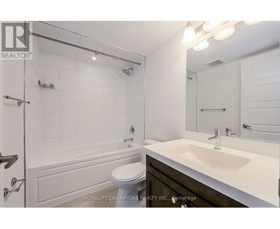 A white bathroom with a toilet, sink, and shower.