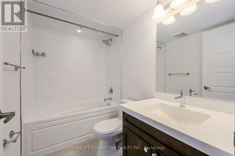 A white bathroom with a toilet, sink, and shower.