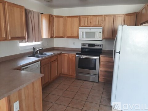 A kitchen with wooden cabinets and a white refrigerator.