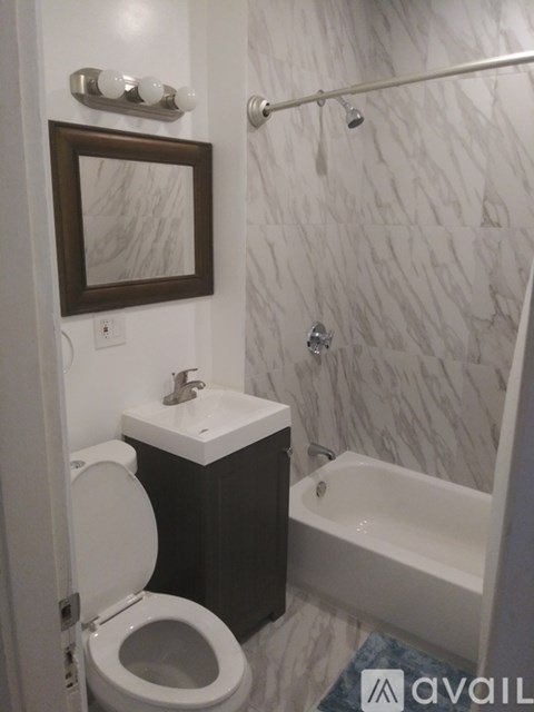 A bathroom with a toilet, sink, and bathtub.