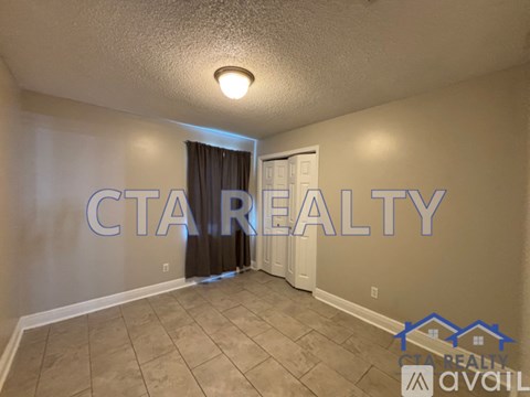 A room with a carpeted floor and a door with curtains.
