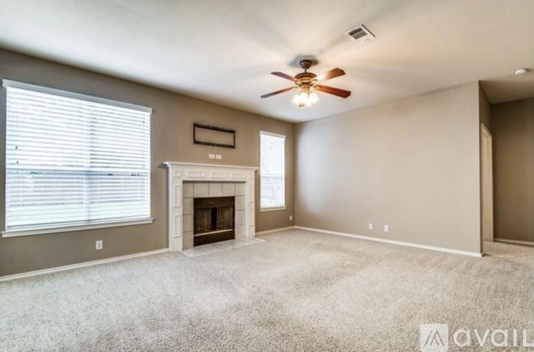 A living room with a fireplace and a ceiling fan.