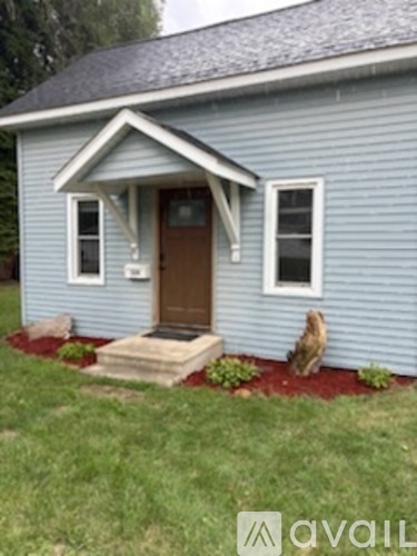 A blue house with a brown door and a window.