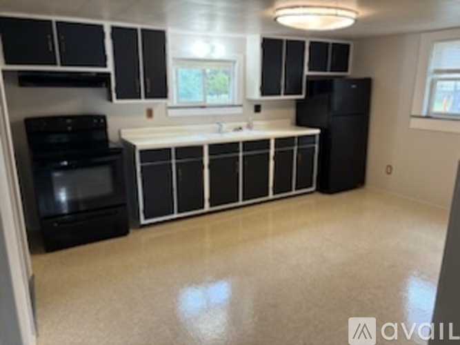 A kitchen with black and white cabinets and appliances.