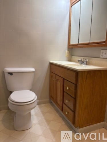A white toilet sits next to a sink in a bathroom.