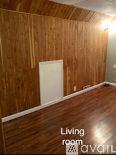 A living room with wood paneling and a white door.
