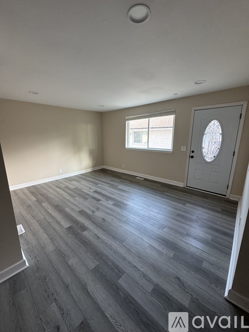 A room with wooden flooring and a white door.