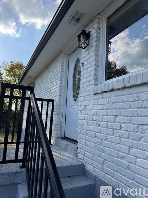 A white house with a black railing and a white door.