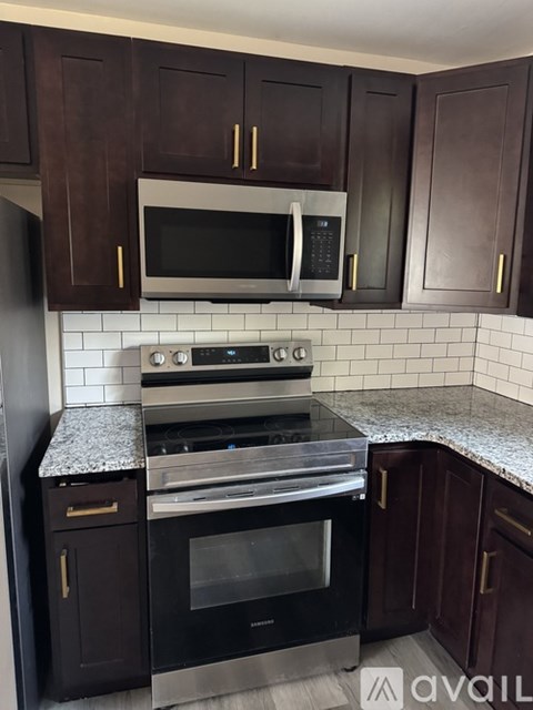 A kitchen with dark brown cabinets and a black oven.