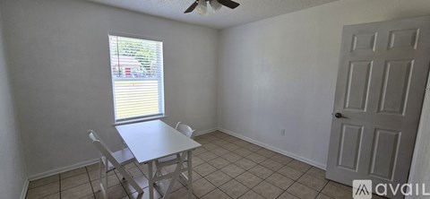A dining room with a table and chairs and a window.