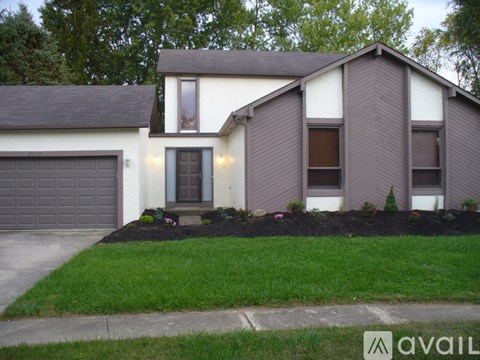 A house with a grey garage door and a brown window.