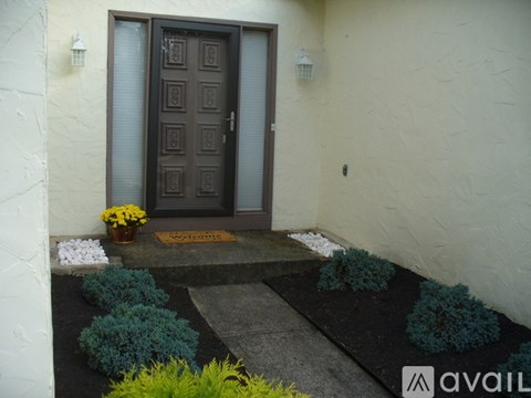 A brown door with a glass panel is flanked by two wall sconces.