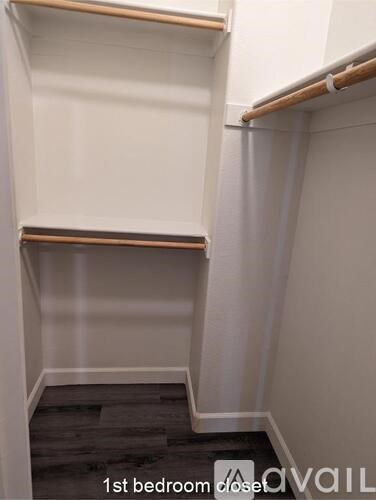 A room with a bedroom closet and a wooden floor.