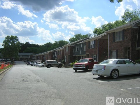 A row of houses with cars parked in front.
