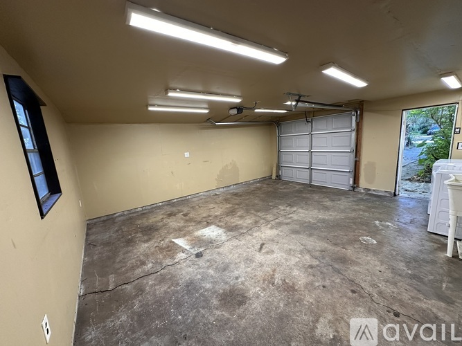 A spacious garage with a white chair and a window.