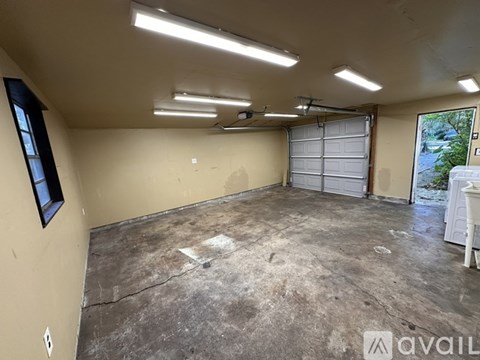 A spacious garage with a white chair and a window.