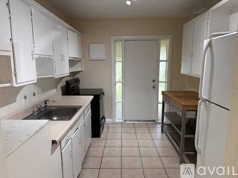 A kitchen with white cabinets and a black dishwasher.