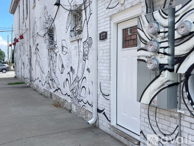 A white building with black graffiti on it.