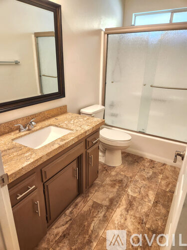 A bathroom with a sink, toilet, and a shower.