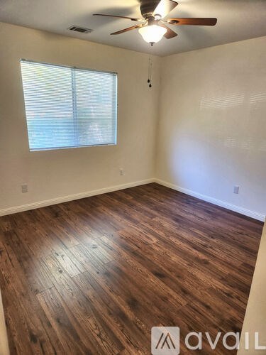 A room with wooden flooring and a ceiling fan.