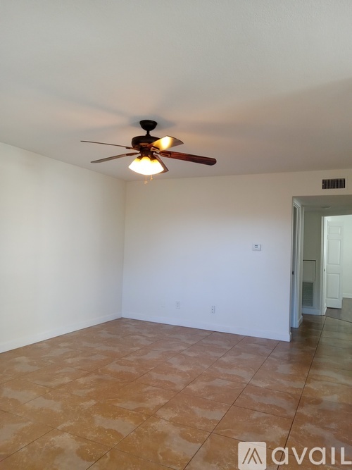A room with a ceiling fan and tile flooring.