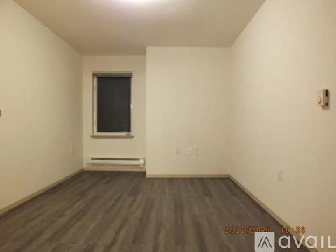A room with wooden flooring and a window.