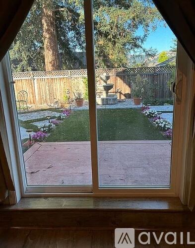 A view from a window looking out to a garden with a fountain.