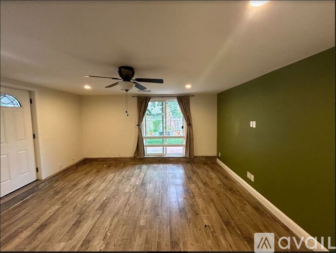 A room with wooden floors and a ceiling fan.