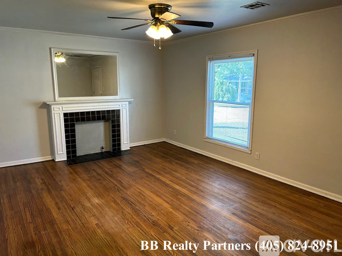 A room with a fireplace and a ceiling fan.