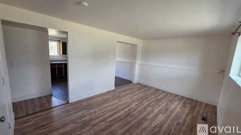 A room with wooden flooring and white walls is available for rent.