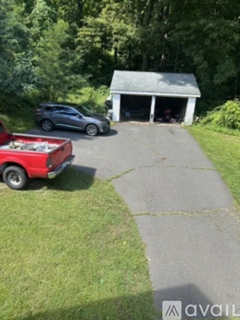 A red truck is parked in a driveway next to a garage.